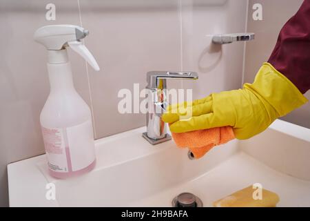 Handglobt Reinigung Chrom Wasserhahn im Badezimmer Stockfoto