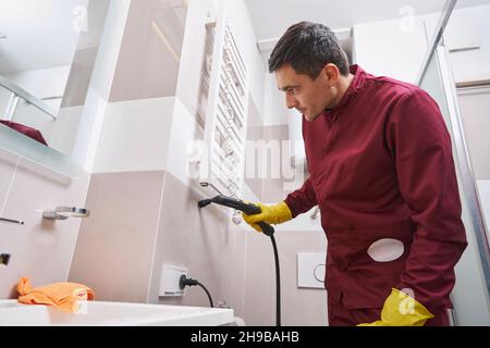 Konzentrierte Dampfreinigungsanlage an der Badezimmerwand Stockfoto