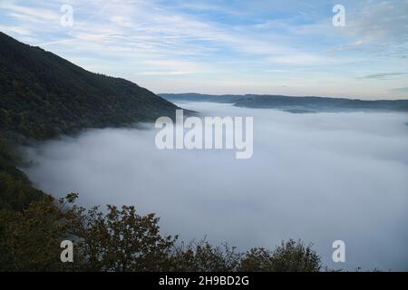 Nebel steigt auf den Bergen der kleinen Saarschleife. Mystische Stille an der Saar im Saarland. Stockfoto