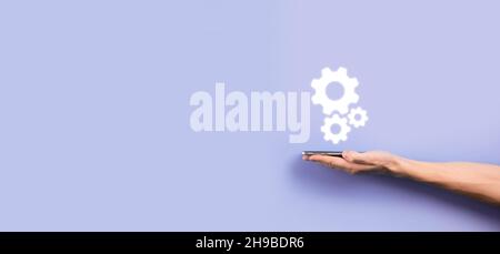 Hand hält Metall Zahnräder und Zahnräder Mechanismus der Interaktion Teamwork Konzept, Hand halten Gruppe von virtuellen Zahnräder Rad. Stockfoto