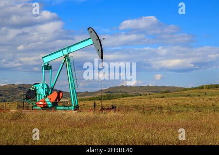 Ein Ölpumpenbock in Alberta, Kanada. Ein Ölpumpenheber ist der Overground-Antrieb für eine Hubkolbenpumpe in einer Ölbohrung. Stockfoto