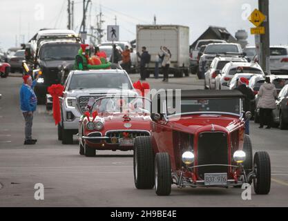 Richmond, Kanada. 5th Dez 2021. Während der Christmas Car Cruise am 5. Dezember 2021 in Richmond, British Columbia, Kanada, laufen Oldtimer durch eine Straße. Die jährliche Veranstaltung zog Dutzende von Oldtimern an, um durch die Straßen zu ziehen und die Freude der Weihnachtszeit zu verbreiten. Quelle: Liang Sen/Xinhua/Alamy Live News Stockfoto