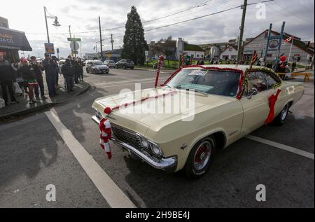 Richmond, Kanada. 5th Dez 2021. Ein Oldtimer wird während der Christmas Car Cruise am 5. Dezember 2021 in Richmond, British Columbia, Kanada, durch eine Straße gefahren. Die jährliche Veranstaltung zog Dutzende von Oldtimern an, um durch die Straßen zu ziehen und die Freude der Weihnachtszeit zu verbreiten. Quelle: Liang Sen/Xinhua/Alamy Live News Stockfoto