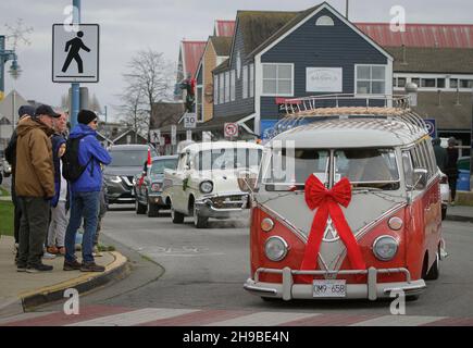 Richmond, Kanada. 5th Dez 2021. Während der Christmas Car Cruise am 5. Dezember 2021 in Richmond, British Columbia, Kanada, laufen Oldtimer durch eine Straße. Die jährliche Veranstaltung zog Dutzende von Oldtimern an, um durch die Straßen zu ziehen und die Freude der Weihnachtszeit zu verbreiten. Quelle: Liang Sen/Xinhua/Alamy Live News Stockfoto