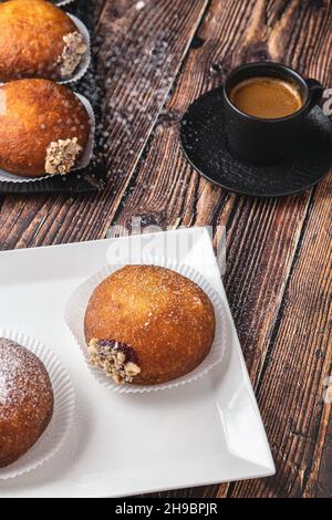 Bombolon oder Bomboloni ist ein italienisches gefülltes Donut- und Snackfutter. Deutsche Krapfen - Krapfen oder berliner - gefüllt mit Marmelade und Schokolade Stockfoto