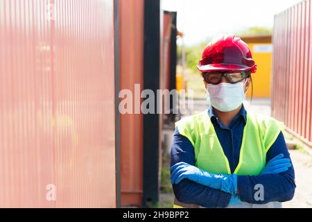 Lateinischer Arbeiter mit Schutzmaske, Schutzhelm und Schutzweste. Stockfoto