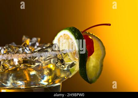 Kalter Cocktail mit Eis. Cocktail garniert mit Kirsche und Limette. Stockfoto