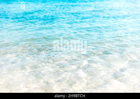 Luftaufnahme des klaren türkisfarbenen Meeres und der Wellen. Sanfte Meereswelle am Sandstrand Stockfoto