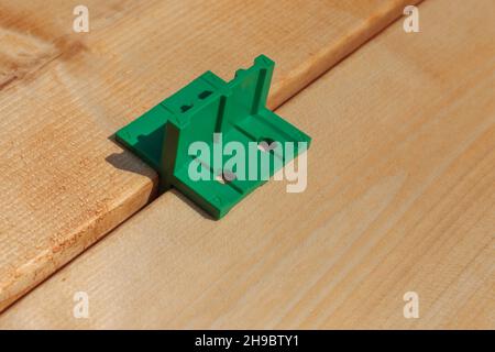 Terrassenbau, Verwendung von Bodenabstandshaltern. Deckbrett Lückengänge, Werkzeuge. Einstellen des korrekten Abstands. Stockfoto