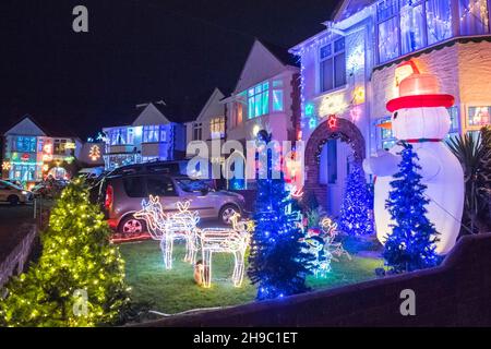 Poole, Dorset, Großbritannien. 5th. Dezember 2021. Häuser in festlichen Weihnachtslichtern an der Runton Road in Poole, Dorset. Die beleuchteten Weihnachtsausstellungen werden seit etwa zwanzig Jahren von den Bewohnern organisiert und sammeln aus Spenden der vielen Besucher Gelder für lokale Wohltätigkeitsorganisationen. Bildnachweis: Graham Hunt/Alamy Live News Stockfoto