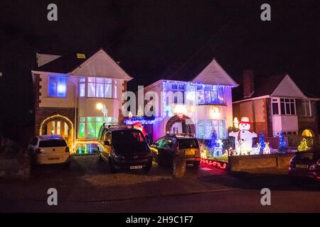 Poole, Dorset, Großbritannien. 5th. Dezember 2021. Häuser in festlichen Weihnachtslichtern an der Runton Road in Poole, Dorset. Die beleuchteten Weihnachtsausstellungen werden seit etwa zwanzig Jahren von den Bewohnern organisiert und sammeln aus Spenden der vielen Besucher Gelder für lokale Wohltätigkeitsorganisationen. Bildnachweis: Graham Hunt/Alamy Live News Stockfoto