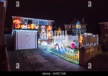 Poole, Dorset, Großbritannien. 5th. Dezember 2021. Häuser in festlichen Weihnachtslichtern an der Runton Road in Poole, Dorset. Die beleuchteten Weihnachtsausstellungen werden seit etwa zwanzig Jahren von den Bewohnern organisiert und sammeln aus Spenden der vielen Besucher Gelder für lokale Wohltätigkeitsorganisationen. Bildnachweis: Graham Hunt/Alamy Live News Stockfoto