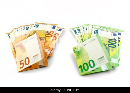 Makrofoto der 100- und 50-Euro-Banknote der Europäischen Union, die auf einem weißen Hintergrund isoliert auf separaten Stapeln nebeneinander liegt. Stockfoto