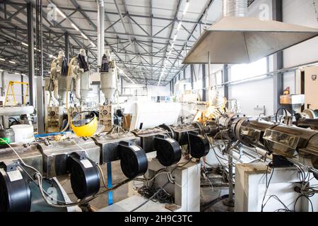 Werkstatt mit Extrudern zur Herstellung von Kunststoffrohren. High-Speed-Extrusionslinie von Wasser supply und Gasleitung. Fertigungsstätte. Stockfoto