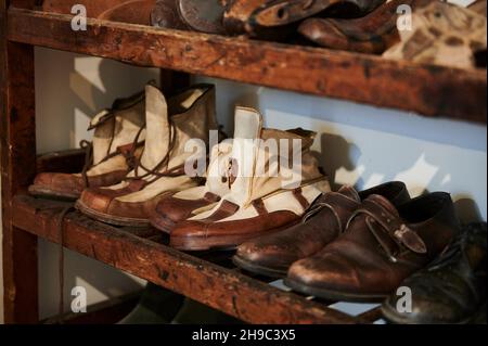 Verschiedene Vintage-Schuhe in einer Reihe auf den alten Regalen, Innenraum des Ethnographischen Museums von Artziniega, Alava, Baskenland, Euskadi, Euskal Herria, Sp Stockfoto