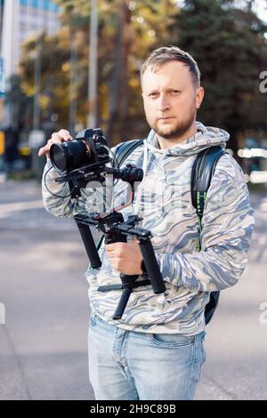 Professioneller Videofilmer mit gimball-Ausrüstung vor der Aufnahme. Er ist bereit für die Videoarbeit Stockfoto