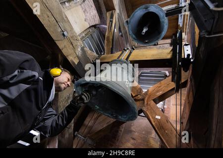 Aachen, Deutschland. 06th Dez 2021. Norbert Jachtmann, Glockenexperte, prüft Glocke 8 (ab 1659) bei einer Routinewartung aller acht Domglocken. Die acht zum Teil über 300 Jahre alten Glocken werden jedes Jahr zu Beginn der Adventszeit von Experten gewartet, und in diesem Jahr nimmt ein Glockenexperte Teil. Quelle: Rolf Vennenbernd/dpa/Alamy Live News Stockfoto