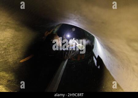 Aachen, Deutschland. 06th Dez 2021. Christian Kerkhoff, Glockengitter, zieht die Schrauben des Klappers in der Glocke 'Karl' (von 1659) während einer Routinewartung aller acht Domglocken an. Die acht Glocken, die zum Teil über 300 Jahre alt sind, werden jedes Jahr zu Beginn der Adventszeit von Experten gewartet, und in diesem Jahr ist ein Glockenexperte dabei. Quelle: Rolf Vennenbernd/dpa/Alamy Live News Stockfoto