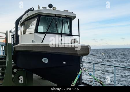 Das Boot ist auf einer Halterung montiert, die mit Sicherheitsgurten gesichert ist. Multifunktionales Davit-Boot, Frachtschiff-Rettungsboot Stockfoto