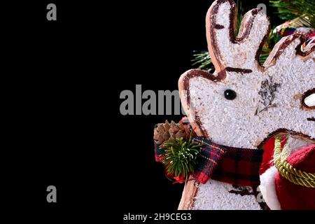 Foto eines weissen Korkornaments mit einer typischen roten Schleife.das Foto wurde im Studio auf schwarzem Hintergrund und im horizontalen Format aufgenommen. Stockfoto