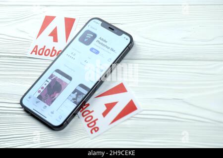 CHARKOV, UKRAINE - 5. MÄRZ 2021: Adobe photoshop Icon und Anwendung aus dem App Store auf dem iPhone 12 pro Display-Bildschirm auf weißem Holztisch Stockfoto