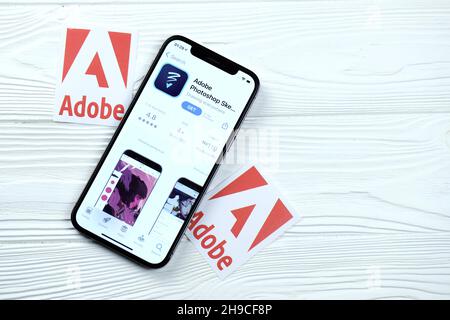 CHARKOV, UKRAINE - 5. MÄRZ 2021: Adobe photoshop Icon und Anwendung aus dem App Store auf dem iPhone 12 pro Display-Bildschirm auf weißem Holztisch Stockfoto