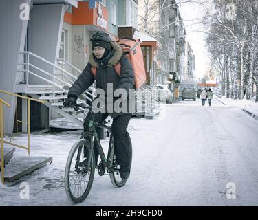 17th. November 2021, Russland, Tomsk, Fahrradkurier auf der Straße Stockfoto