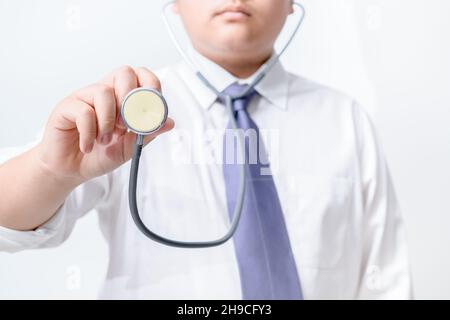 Junger Arzt hält Stethoskop auf weißem Hintergrund. Asiatisches männliches Modell, Konzept kosmetische Chirurgie Stockfoto