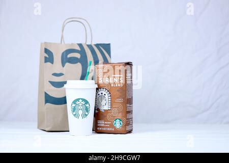 CHARKOW, UKRAINE - 15. MÄRZ 2021: Starbucks Produktion auf weißem Holztisch. Starbucks Corporation ist eine multinationale Kette von Kaffeehäusern und Roaste Stockfoto