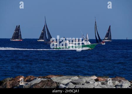 Das Wassertaxi von St Maxime nach St Tropez fährt an Yachten vorbei, die im Golf von St Tropez, an der Côte d'Azur, Var, Provence-Alpes-Côte d'Azur, Frankreich, Rennen Stockfoto