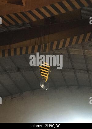 Industriekranhaken für schwere Lasten mit gelben Sicherheitsstreifen Stockfoto