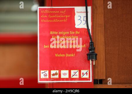 Quedinburg, Deutschland. 06th Dez 2021. Ein Schild mit der Corona-Regel hängt an einer Verkaufshütte auf dem Marktplatz. Seit heute wird der Weihnachtsmarkt in der Adventstadt Quedlinburg abgebaut. Aufgrund der hohen Anforderungen von Corona ist die Besucherzahl in den letzten Tagen stark zurückgegangen. Insgesamt 75 Prozent der Händler baten darum, den Weihnachtsmarkt nach 12 Tagen vorzeitig zu beenden. Die Entscheidung wurde am Sonntag getroffen. Quelle: Matthias Bein/dpa-Zentralbild/ZB/dpa/Alamy Live News Stockfoto