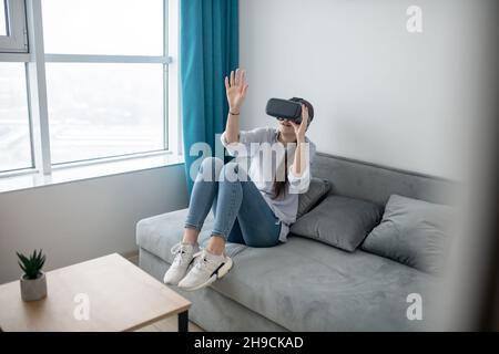 Kaukasische Frau in VR-Brille, die die virtuelle Realität erforscht Stockfoto