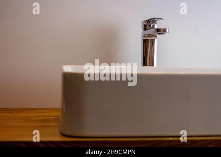 Minimalistisches Bad mit Waschbecken und Holztisch Stockfoto