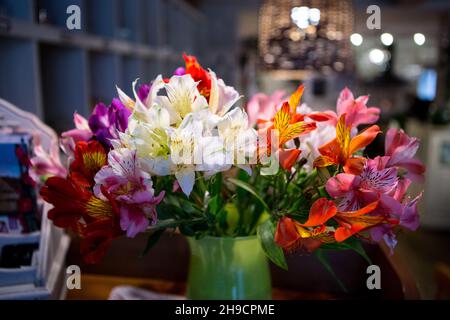 Ein Blumenstrauß ALSTROMERIA in einer Vase im Inneren des Restaurants, Café. Stockfoto