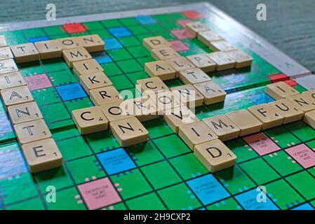 Nahaufnahme des Scrabble-Spielbretts mit koronabezogenen Wörtern Stockfoto