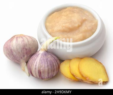 Ingwer und Knoblauch mit Paste auf weißem Hintergrund Stockfoto