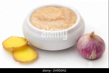 Ingwer und Knoblauch mit Paste auf weißem Hintergrund Stockfoto