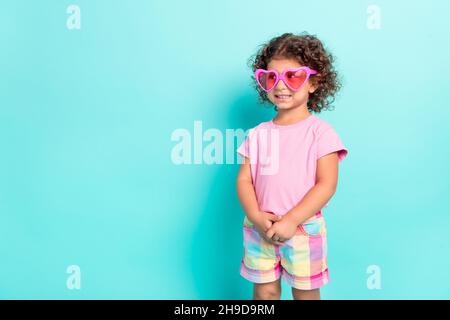 Portrait von attraktiven fröhlich schüchtern Mädchen tragen große rosa specs denken kopieren Raum isoliert über hell blaugrün türkis Farbe Hintergrund Stockfoto