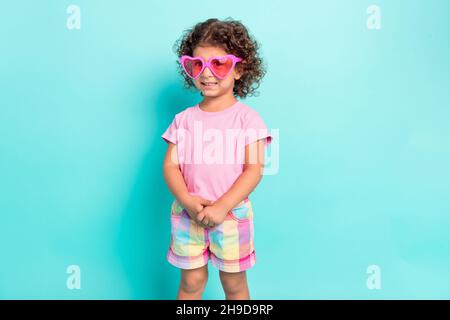 Portrait von attraktiven fröhlichen Mädchen tragen große rosa specs posiert isoliert über hellen blaugrün türkis Farbe Hintergrund Stockfoto