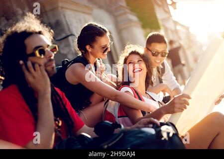 Freunde erkunden alte Stadt Festung. Eine gute Zeit auf der Straße zu haben. Sitzen auf Treppen. Stockfoto