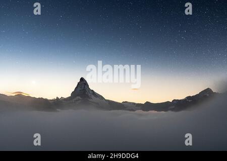 Sterne am Nachthimmel über dem Matterhorn Peak, die aus dem Nebel aufsteigen, Zermatt, Kanton Wallis, Schweiz Stockfoto