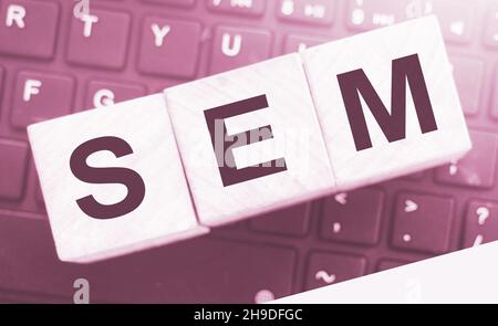SEM Search Engine Marketing auf einem hölzernen Würfel geschrieben, der auf Computertastatur gesetzt wird. Optimierung Online Business Technologie Konzept Stockfoto