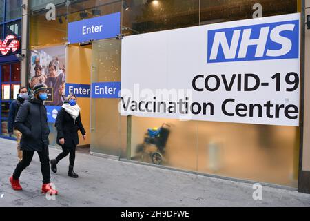 London, Großbritannien. 06th Dez 2021. Fußgänger, die am NHS Covid-19 Impfzentrum in Westfield, Stratford, vorbeikommen.das Vereinigte Königreich führt Pandemiebeschränkungen wieder ein, während die Omicron COVID-19-Variante auftaucht. Booster-Jabs werden im Januar erhältlich sein. Kredit: SOPA Images Limited/Alamy Live Nachrichten Stockfoto