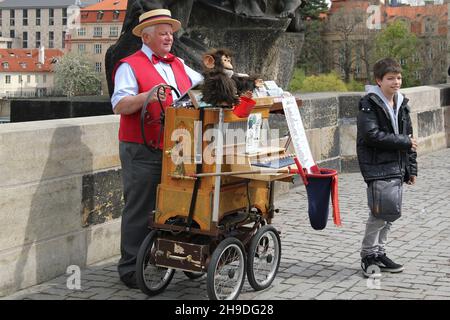 PRAG, TSCHECHIEN - 24. APRIL 2012: Ein nicht identifizierter Straßenorgelschleifer gibt Konzerte auf der Karlsbrücke. Stockfoto