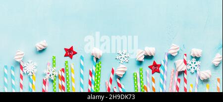 Trinkpapier Bunte Trinkhalme für Neujahrscocktails auf hellblauem Hintergrund. Weihnachtskarte. Draufsicht. Stockfoto