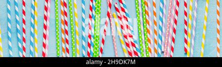 Trinkpapier Bunte Trinkhalme für Neujahrscocktails auf hellblauem Hintergrund. Weihnachtskarte. Draufsicht. Stockfoto