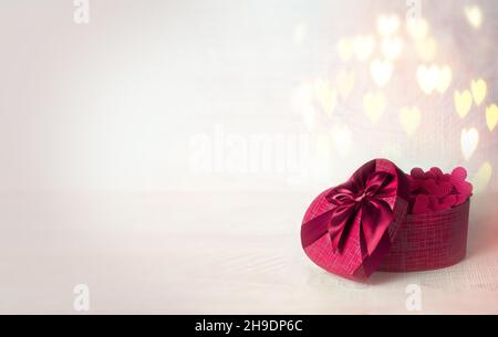 Valentinstagskonzept mit Geschenkbox über herzförmigem Bokeh. Urlaubskonzept. Stockfoto