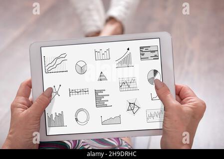 Grafisches Analysekonzept, das auf einem Tablet dargestellt wird, das von einer Frau gehalten wird Stockfoto