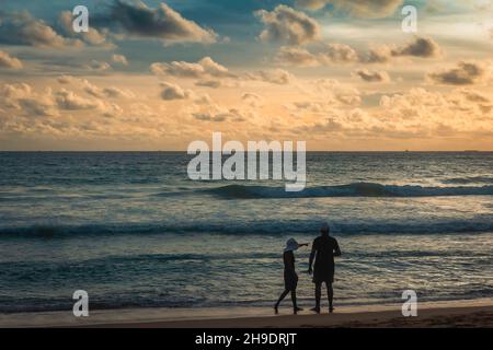 Mann und Frau am Strand blicken in die Ferne Stockfoto